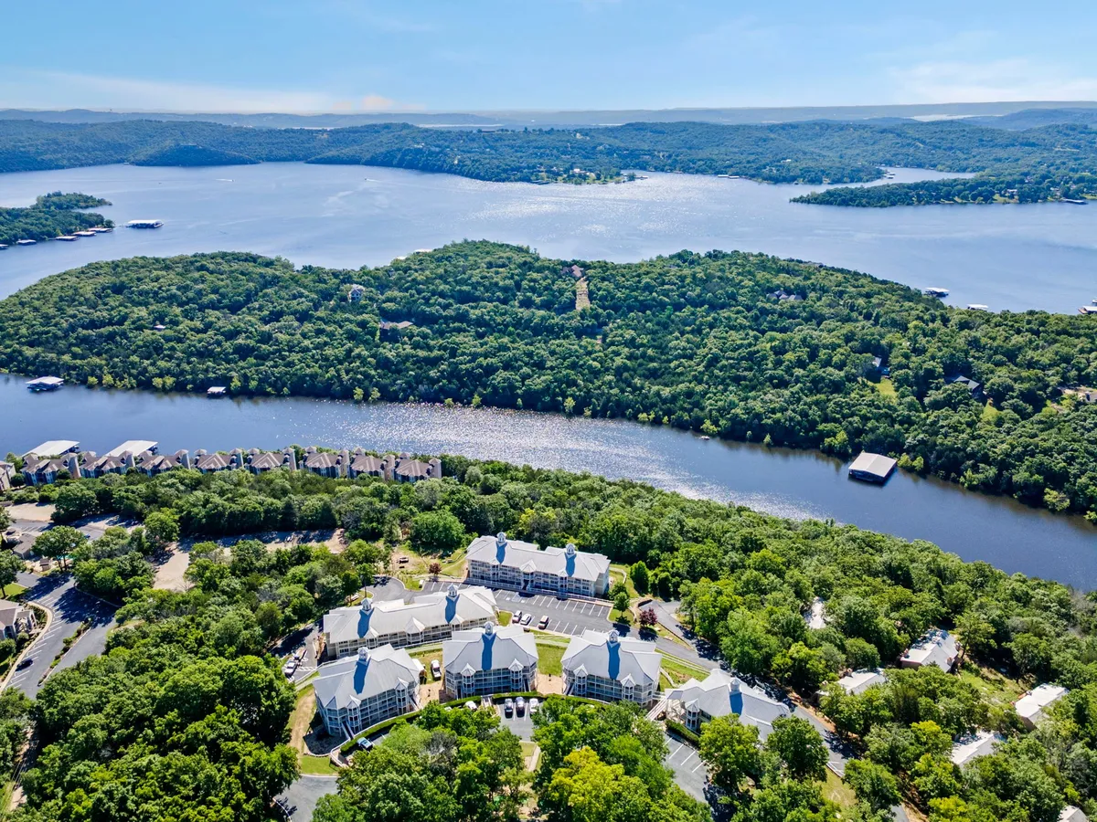 A broad view of Table Rock Lake framed by green hills, buildings, and visible docks. The image conveys a peaceful setting with plenty of space for boating, fishing, and lakeside relaxation, matching the section’s activity suggestions.